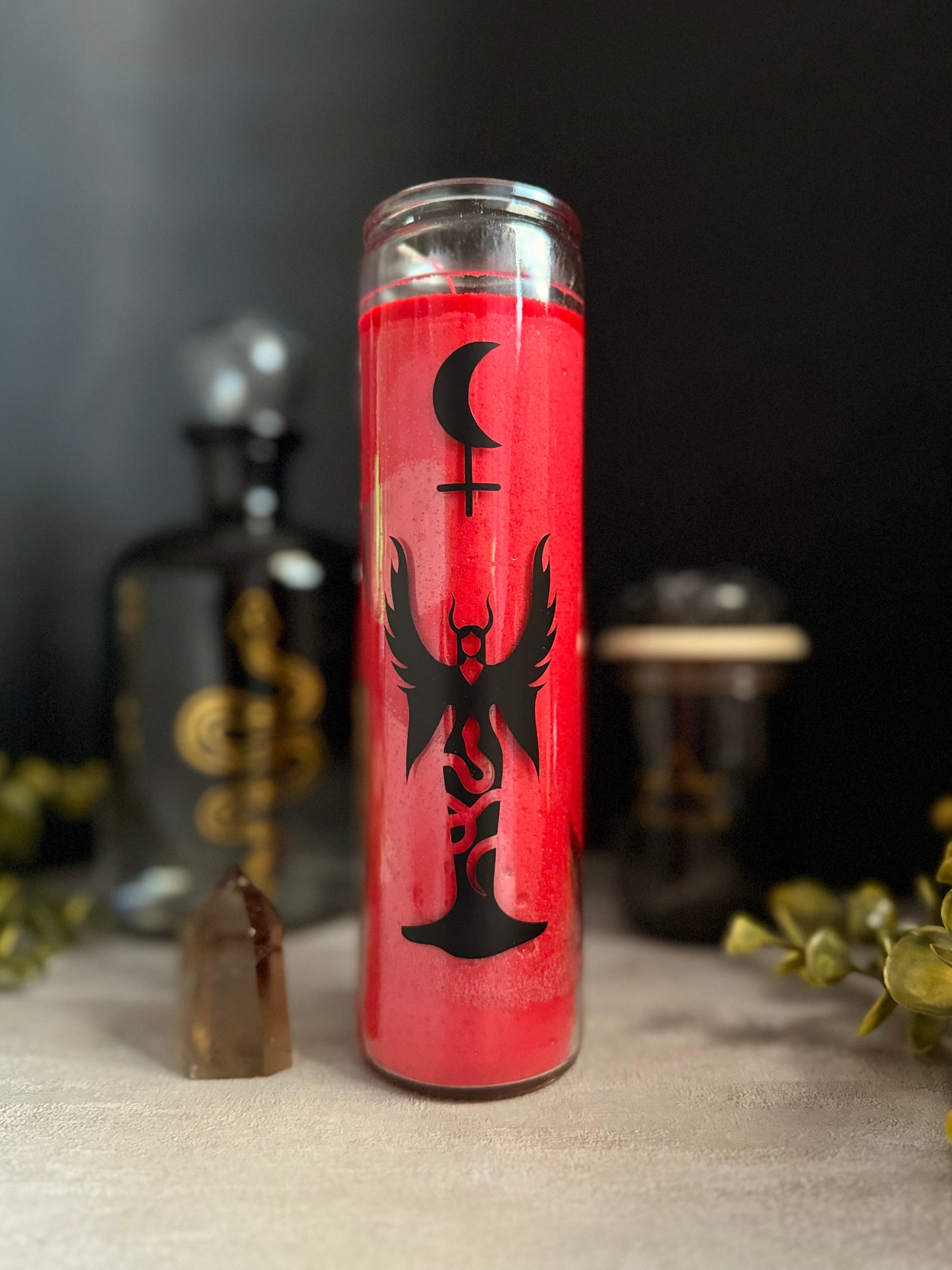 Red candle with black symbol on a dark background